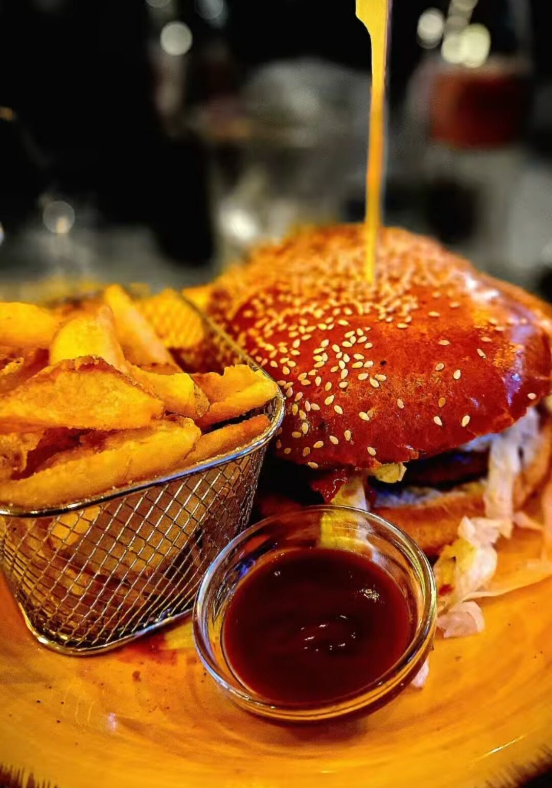 Hamburger artigianale di Juras Food & Drink con patate fritte e salsa BBQ